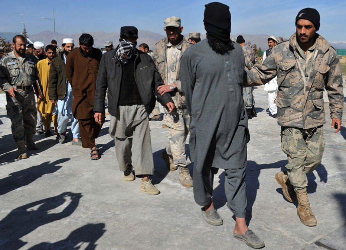 Taliban fighters are led by police as they are displayed to the media at a police headquarters in Jalalabad on March 2, 2013. (AFP Photo/Noorullah Shirzada)