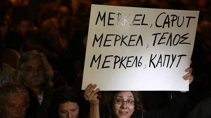 A empoyee cipriota dos gritos Laiki (Popular) do Banco como ela segura um cartaz leitura em grego, russo e Inglês "Merkel Caput" durante um protesto em frente ao Parlamento em 21 de março 2013 em Nicósia (AFP Photo / Patrick Baz)