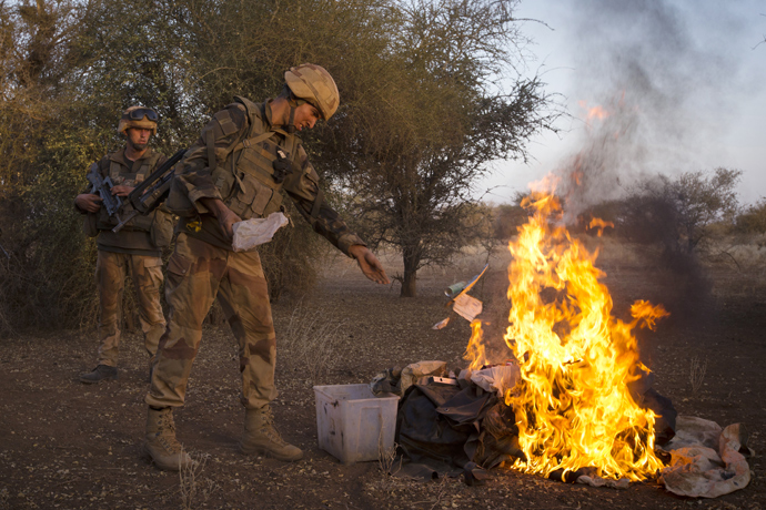 French soldiers from the 92nd Regiment Infanterie burn items allegedly belonging to Mujao forces on April 8, 2013 during a military operation some 105 kilometers North of Gao (AFP Photo / Joel Saget) 
