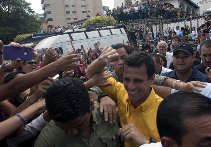 Venezuelan opposition presidential candidate Henrique Capriles greets supporters after voting in Caracas, on April 14, 2013 (AFP Photo / Geraldo Caso) 