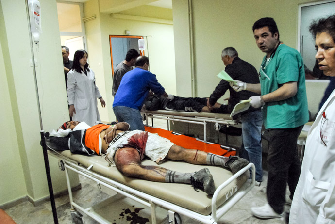Dos trabajadores migrantes reciban un tratamiento de primeros auxilios de un disparo el 17 de abril de 2013 en Varda.  (AFP Photo / Eurokinissi)