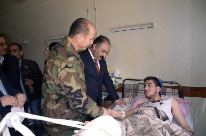 Funcionários do governo sírio e militares visitar uma vítima de armas químicas em um hospital em Aleppo, 21 de março de 2013. (Reuters / George Ourfalian)