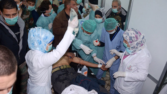 In this image made available by the Syrian News Agency (SANA) on March 19, 2013, medics and other masked people attend to a man at a hospital in Khan al-Assal in the northern Aleppo province, as Syria's government accused rebel forces of using chemical weapons for the first time. The opposition denied the claim, saying instead that government forces might have used banned weapons. (AFP Photo/SANA)