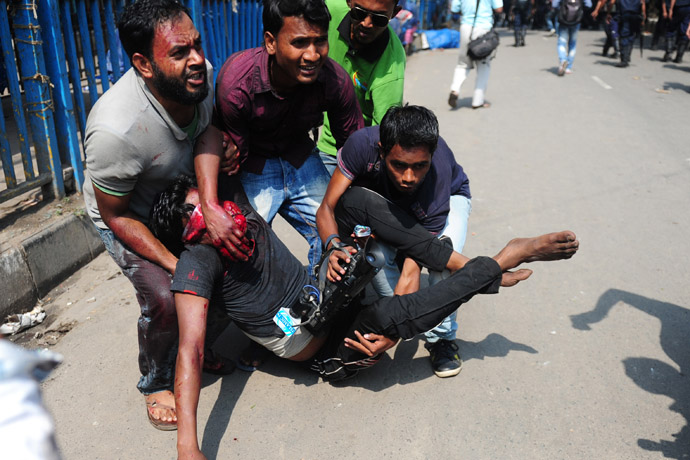  Civilian people carry an injured Islamist protestor during clashes with police in Dhaka on May 5, 2013. (AFP Photo/Munir uz Zaman)