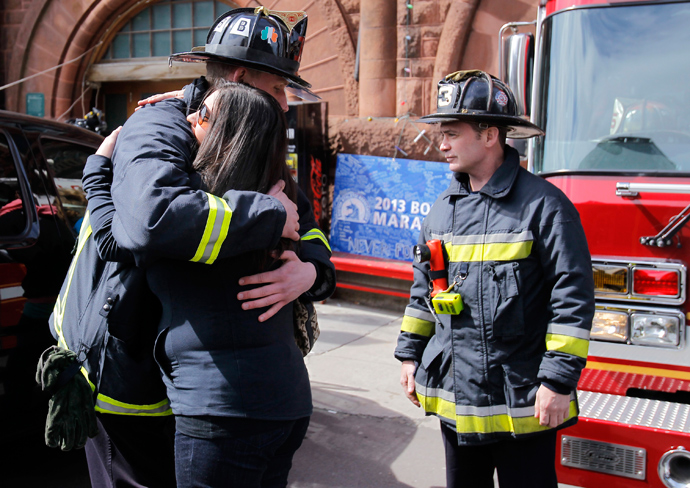 A woman embraces a Boston Firefighter shortly before a moment of silence for the victims of the Boston Marathon bombings marking a week to the day of the bombings at a memorial on Boylston Street in Boston, Massachusetts April 22, 2013 (Reuters / /Jessica Rinaldi)
