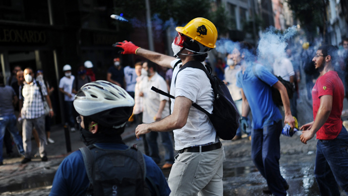 A protester throws back a tear gas canister at riot police during clashes between police and demonstrators in the streets adjacent to Taksim square in Istanbul, on June 16, 2013 (AFP Photo / Bulent Kilic) 