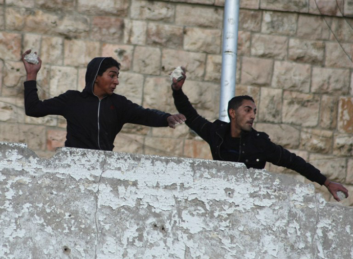 Palestinians throw stones towards Israeli soldiers at a check point guarding the Jewish settlements of Beit Hadasa and Beit Romano during clashes in the Israeli occupied West Bank town of Hebron. (AFP Photo / Hazem Bader)