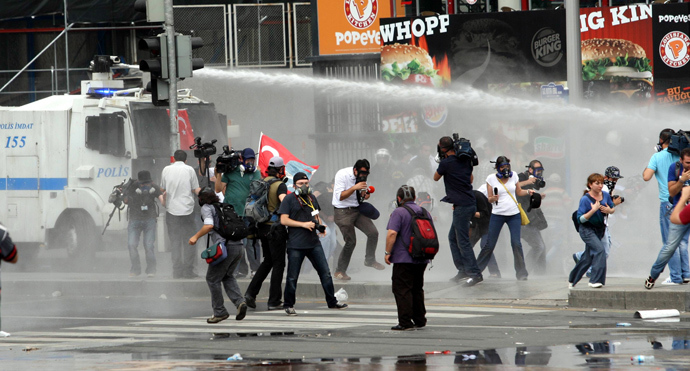 Protesters escape from a water cannon as they clash with police during an anti-government demonstration in Ankara on June 16, 2013 (AFP Photo / Adem Altan)