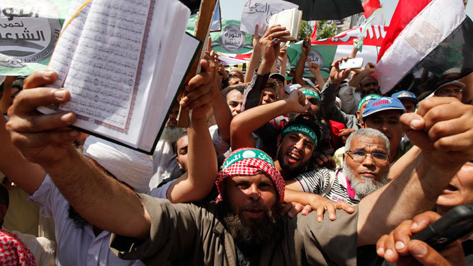 Islamists, members of the brotherhood, and supporters of Egyptian President Mohamed Morsi shout slogans holding the Holy Quran during a protest around the Raba El-Adwyia mosque square in the suburb of Nasr City, Cairo, June 28, 2013.(Reuters / Mohamed Abd El Ghany)
