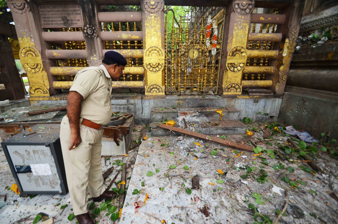 An Indian policeman looks at debris left after several low intensity explosions took place at at the Bodh Gaya Buddhist temple complex injuring two people on July 07,2013 (AFP Photo / STR)