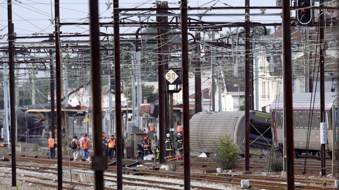 Rescuers work on the site of a train accident in the railway station of Bretigny-sur-Orge on July 12, 2013 near Paris. (AFP Photo / Kenzo Tribouillard)