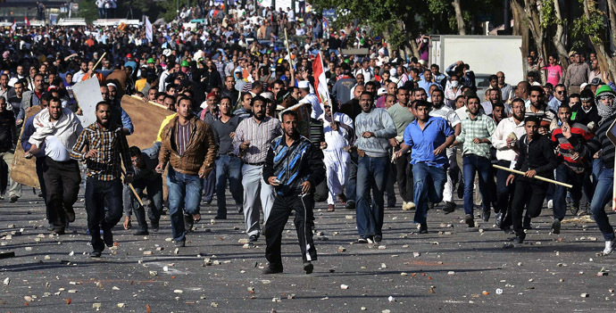 EGYPT: Protesters throw stones during clashes between the Muslim Brotherhood movement's opponents and supporters on April 19, 2013 in central Cairo. (AFP Photo/Mohamed El-Shahed)