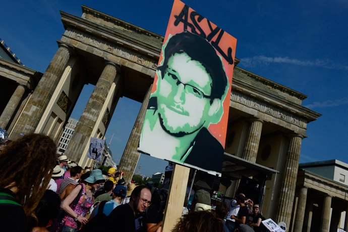 Demonstrators hold up a placard in support of former US agent of the National Security Agency, Edward Snowden in front of Berlin's landmark Brandenburg Gate (AFP Photo / John Macdougall)