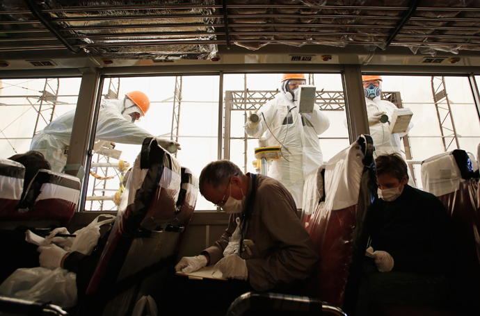 Workers carry out a radiation screening on a bus for a media tour at Tokyo Electric Power Co. (TEPCO)'s tsunami-crippled Fukushima Daiichi nuclear power plant (Reuters / Issei Kato)