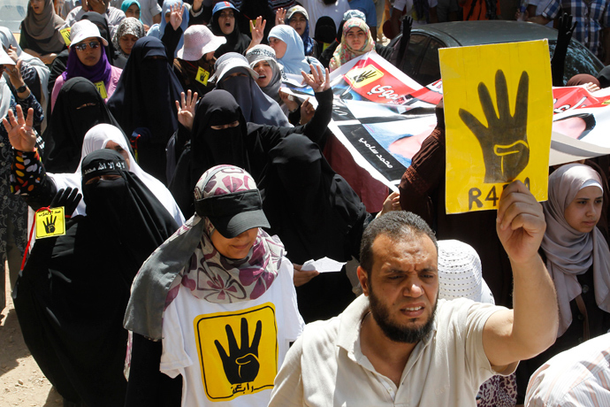 Supporters of Muslim Brotherhood and ousted Egyptian President Mohamed Mursi hold up posters of the "Rabaa" gesture, in reference to the police clearing of Rabaa Adawiya protest camp on August 14, during a protest in Cairo August 23, 2013 (Reuters / Muhammad Hamed)