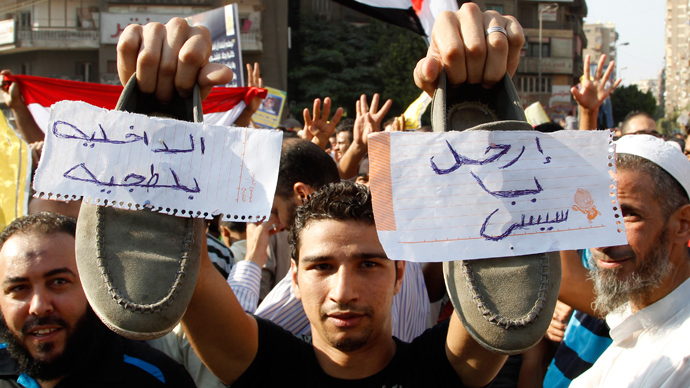 A supporter of Muslim Brotherhood and ousted Egyptian President Mohamed Mursi shows his shoes with notes written on them during a protest in Cairo August 23, 2013 (Reuters / Muhammad Hamed)