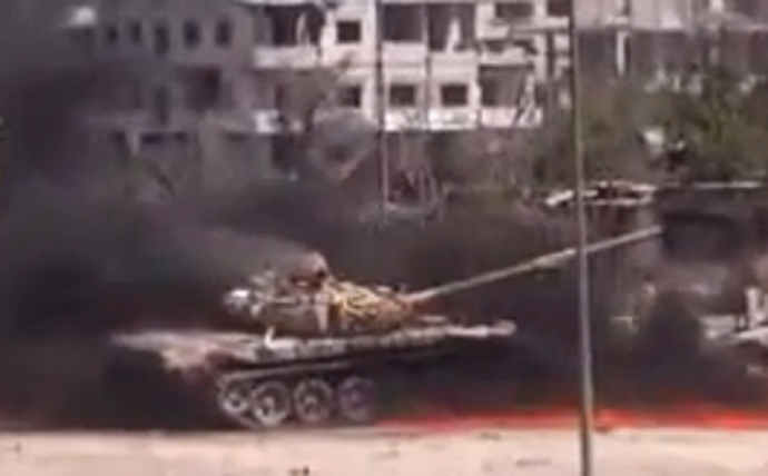 An image grab taken from a video uploaded on YouTube on August 27, 2013 allegedly shows smoke billowing from a Syrian government forces' tank at it was hit by an explosion in a Damascus' suburb (AFP Photo / Youtube)