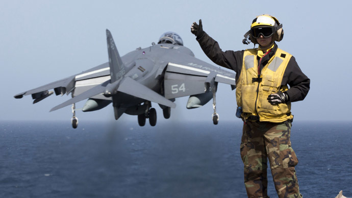 A picture released by the US Navy shows Aviation Boatswain's Mate (Handling) 2nd Class Christiana Marszalek signaling as an AV-8B Harrier takes off from the amphibious assault ship USS Kearsarge (LHD 3) on March 29, 2013 in the Mediterranean Sea. (AFP Photo/US NAVY/Corbin Shea)
