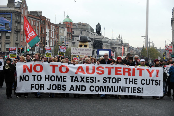 Protestors display placards and banners as they march against Government austerity measures in Dublin, Ireland on November 24, 2012. (AFP Photo/ Barry Cronin)