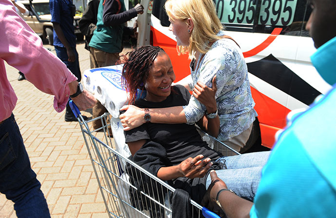 A woman is trolled into an ambulance after masked gunmen stormed an upmarket mall and sprayed gunfire on shoppers and staff, killing at least thirteen on September 21, 2013 in Nairobi. (AFP Photo / Simon Maina)