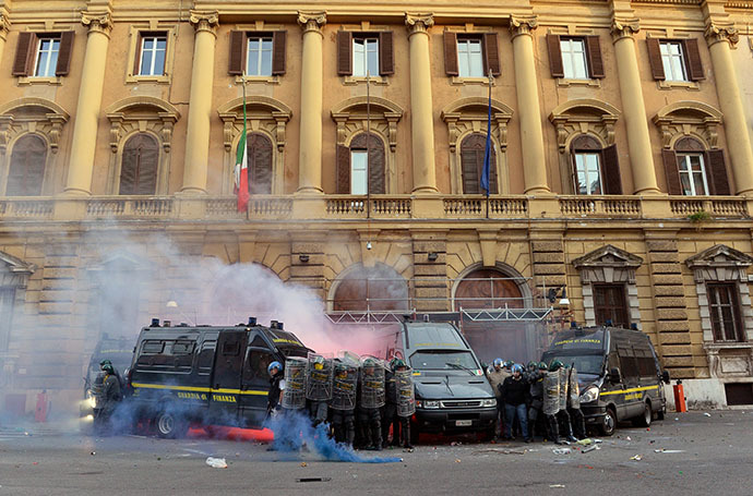 Members of the Guardia di Finanza protect themselves as they stand in front of the Economy minister during clashes on the sidelines of an anti-austerity protest on October 19, 2013 in Rome. (AFP Photo / Alberto Pizzoli)