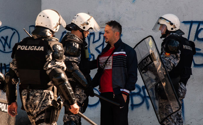 A pedestrian argues with riot policeman during the Pride March in Podgorica, October 20, 2013 (Reuters / Stevo Vasiljevic)