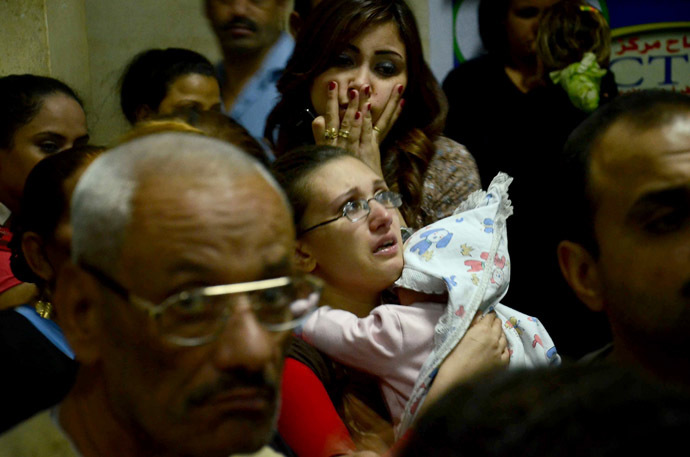 Egyptian women, some in tears, gather inside the Virgin Mary Coptic Christian church in Cairo after gunmen on a motorbike shot dead three people late on October 20, 2013, including an eight-year-old girl, in a shooting attack on a group standing outside the church in the Egyptian capital's Al-Warak neighbourhood following a wedding ceremony. (AFP Photo)