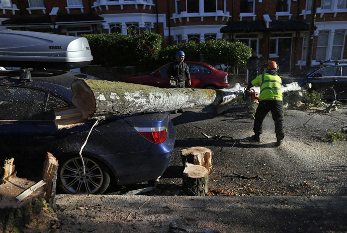 Workers clear a fallen tree from a street in south London October 28, 2013. (Reuters/Andrew Winning)