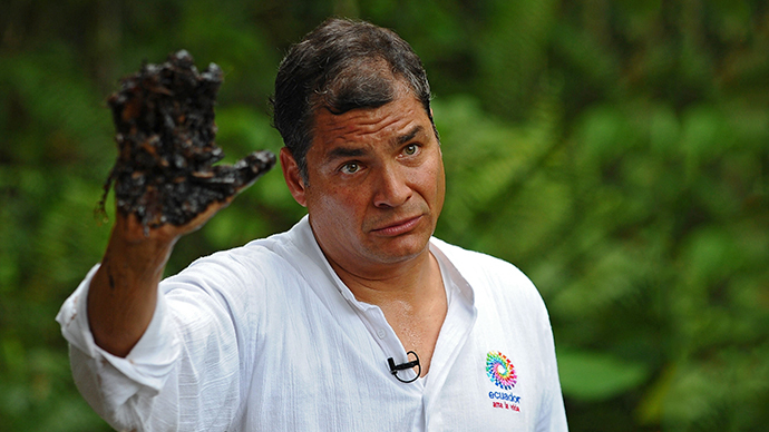 Ecuadorean President Rafael Correa shows his oil-covered hand at Aguarico 4 oil well in Aguarico, Ecuador (AFP Photo / Rodrigo Buendia)