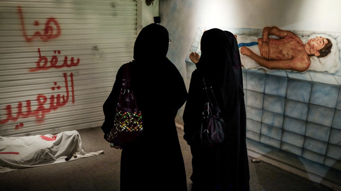 Bahraini women stand in front of an art installation at the 