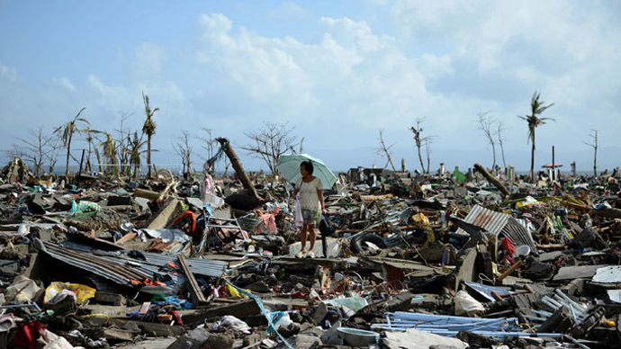 A surivor walks among the debris of houses destroyed by Super Typhoon Haiyan in Tacloban in the eastern Philippine island of Leyte on November 11, 2013.(AFP Photo / Noel Celis)