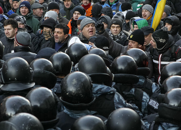 Police stand guard in front of protesters during a demonstration in support of EU integration in front of the Parliament building in Kiev December 3, 2013. (Reuters/Gleb Garanich)