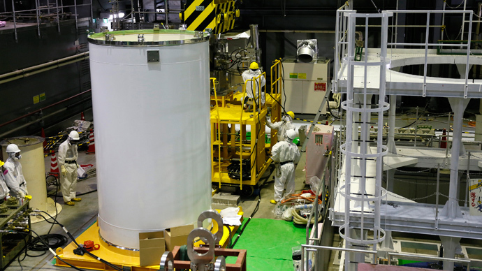 Workers check a transport container and a crane in preparation for the removal of spent nuclear fuel from the spent fuel pool inside the No.4 reactor building at the Tokyo Electric Power Corp's (TEPCO) tsunami-crippled Fukushima Daiichi nuclear power plant, in Fukushima  (Reuters / Kimimasa Mayama / Pool)
