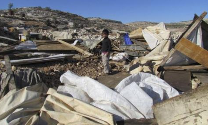 A Bedouin refugee child standing on the site of his demolished home. Image from UNRWA