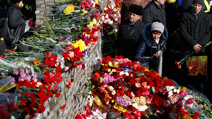 Ihmiset makasi kukkia barrikadeille muistoksi uhrien viimeaikaisten yhteenottojen Kiovan keskustassa 24 helmikuu 2014 (Reuters / David Mdzinarishvili)
