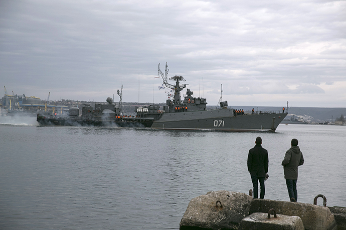 People watch a Russian Navy ship enter the Crimean port city of Sevastopol March 2, 2014. (Reuters / Baz Ratner)