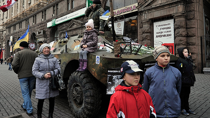 Lapset poseeraavat APC panssaroitu ajoneuvo Kiovan keskustassa 24. helmikuuta 2014 (AFP Photo / Louisa Gouliamaki)