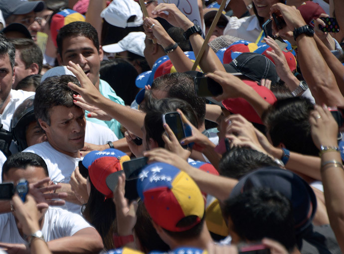 Leopoldo Lopez (L), kiihkeä vastustaja Venezuelan sosialistinen hallitus edessään pidätysmääräyksen jälkeen, kun presidentti Nicolas Maduro määräsi hänet pidätettiin syytettynä murhasta ja väkivaltaan yllyttämisestä, ympäröi kannattajat mielenosoituksen aikana ennen antautua viranomaisille, Caracasissa, on 18 helmikuu 2014.  (AFP Photo / Raul Arboleda)