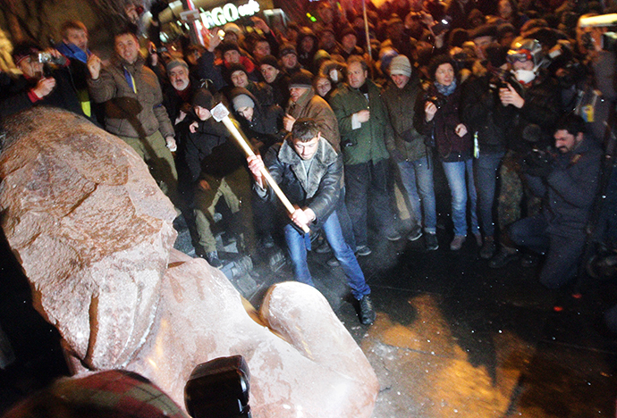 Mielenosoittaja lohkeilevat Leninin patsas on muistomerkki hänen kunniakseen jälkeen se purettiin aikana massa ralli nimeltään "March of Million" Kiovan Itsenäisyyden aukio 8. joulukuuta 2013.  (AFP Photo / Anatoli Boiko)