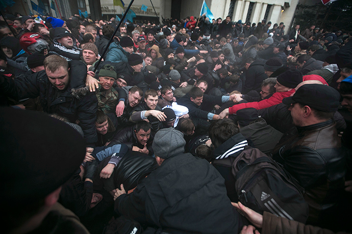 Ukrainian men auttaa vetää toisiaan pois pakokauhu aikana yhteenotoissa mielenosoituksissa hallussa venäläisiä ja Krimin tataarit lähellä Krimin parlamentin rakennus Simferopol 26 helmikuu 2014 (Reuters / Baz Ratner)