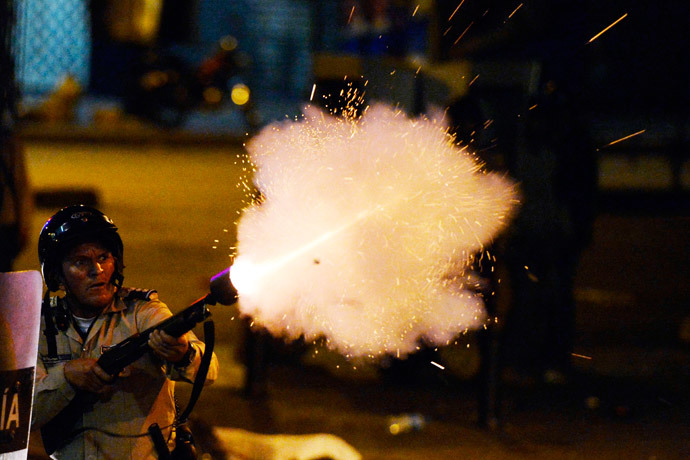 A National Guard member shoots during anti-government protest, in Caracas on March 31, 2014. (AFP Photo / Juan Barreto) 
