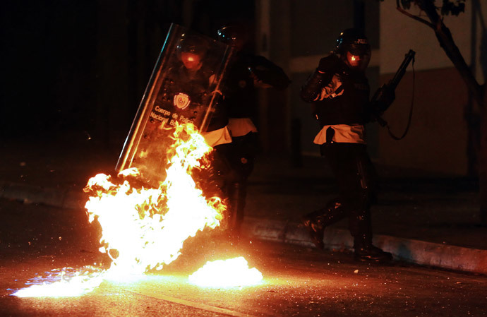 Riot policemen protect themselves from molotov cocktails thrown by anti-government activists during a protest, in Caracas on March 31, 2014. (AFP Photo / Juan Barreto) 