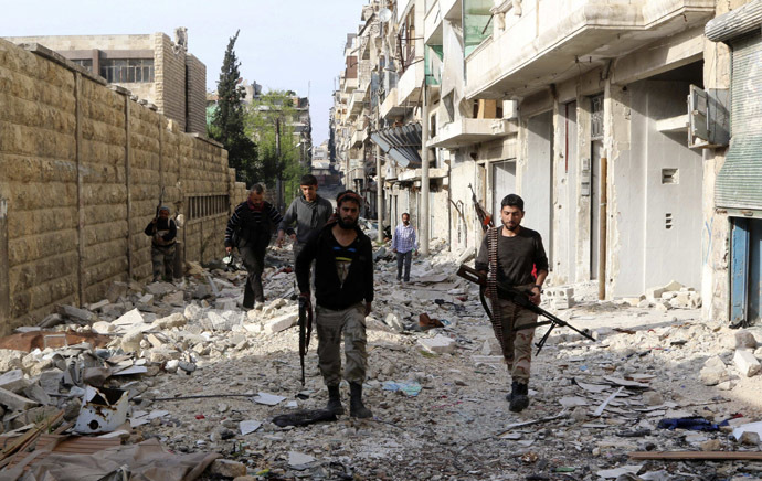 Free Syrian Army fighters walk with their weapons along a damaged street in Bustan al-Basha district in Aleppo April 6, 2014. (Reuters/Mahmoud Hebbo)