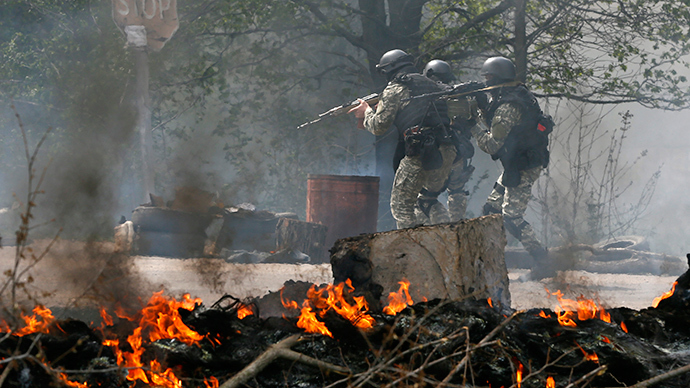 Oficiais das forças de segurança ucranianas passar por um posto de controle incendiado e deixado por manifestantes anti-goverment perto Slavyansk 24 de abril de 2014 (Foto: AFP / Gleb Garanich)