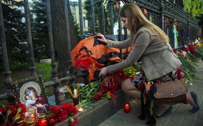 A woman lays flowers by the fence of the Ukrainian embassy in Moscow on May 3, 2014, in honour of people killed during clashes in Odessa. (AFP Photo)