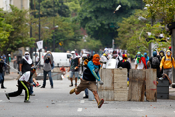 Um manifestante anti-governo joga um coquetel molotov durante os distúrbios com a polícia em Caracas 17 de abril de 2014 (Reuters / Christian Veron)