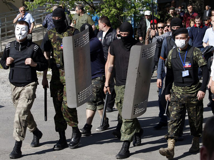 Masked activists march to seize a regional television station in the eastern Ukrainian city of Donetsk, home of the local telecommunication antennas and studios of the regional TV station Channel 27, on April 27, 2014. (AFP Photo / Anatoliy Stepanov)