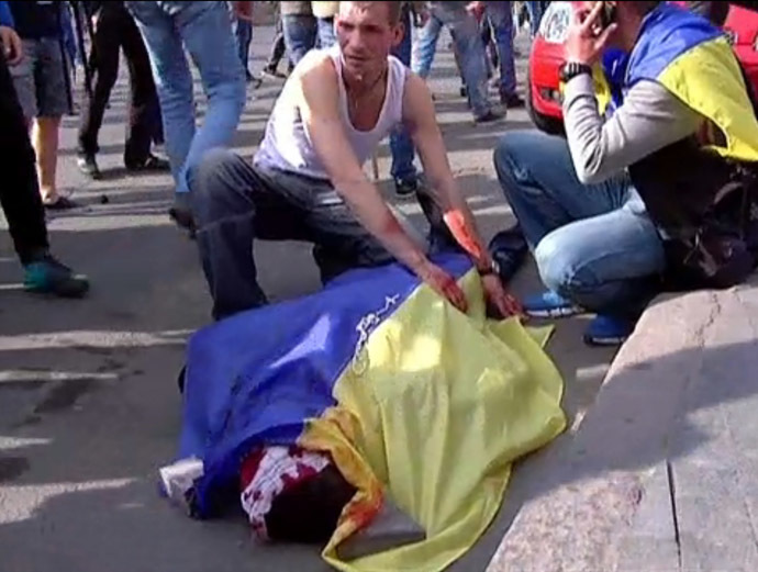 This still grabbed on TV images released by INTER, shows a man covering the bloodied body of a man with an Ukrainian flag during a demonstration on May 2, 2014 in Odessa. (AFP/Inter)