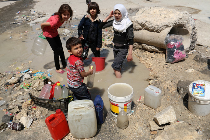 Syrian children collect buckets of stagnant murky water from the side of a road in a rebel-held area in the northern city of Aleppo on May 12, 2014. (AFP Photo/Zein Al-Rifai)