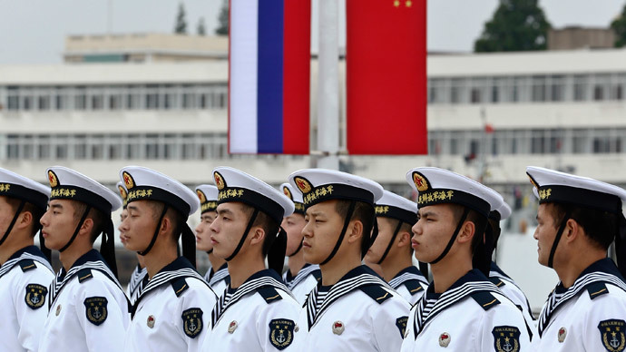Chinese sailors stand in formation in front of national flags of Russia (L) and China, as they get ready for a welcoming ceremony for Russian naval vessels ahead of the "Joint Sea-2014" naval drill, at a port in Shanghai, May 18, 2014.(Reuters / China Daily)